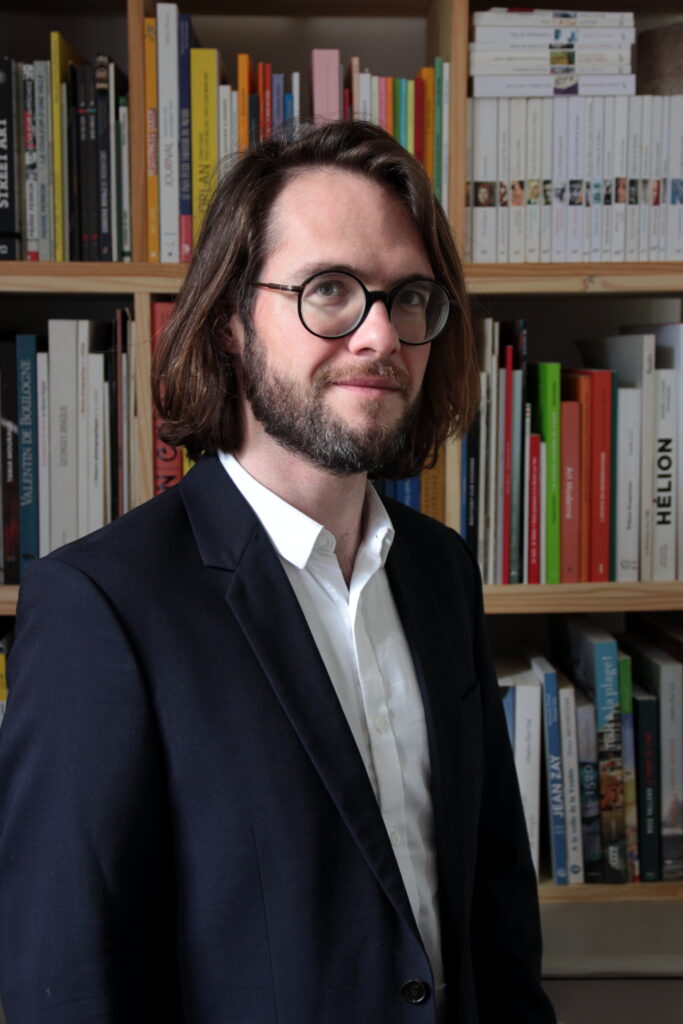 Portrait William Chevillon devant bibliothèque
